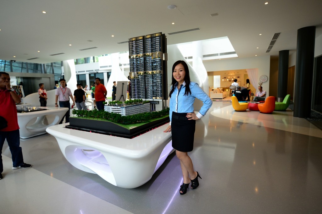 Grace Foo, Sales & Marketing Manager of Pantai Sentral Park standing next to a model of Secoya Residences